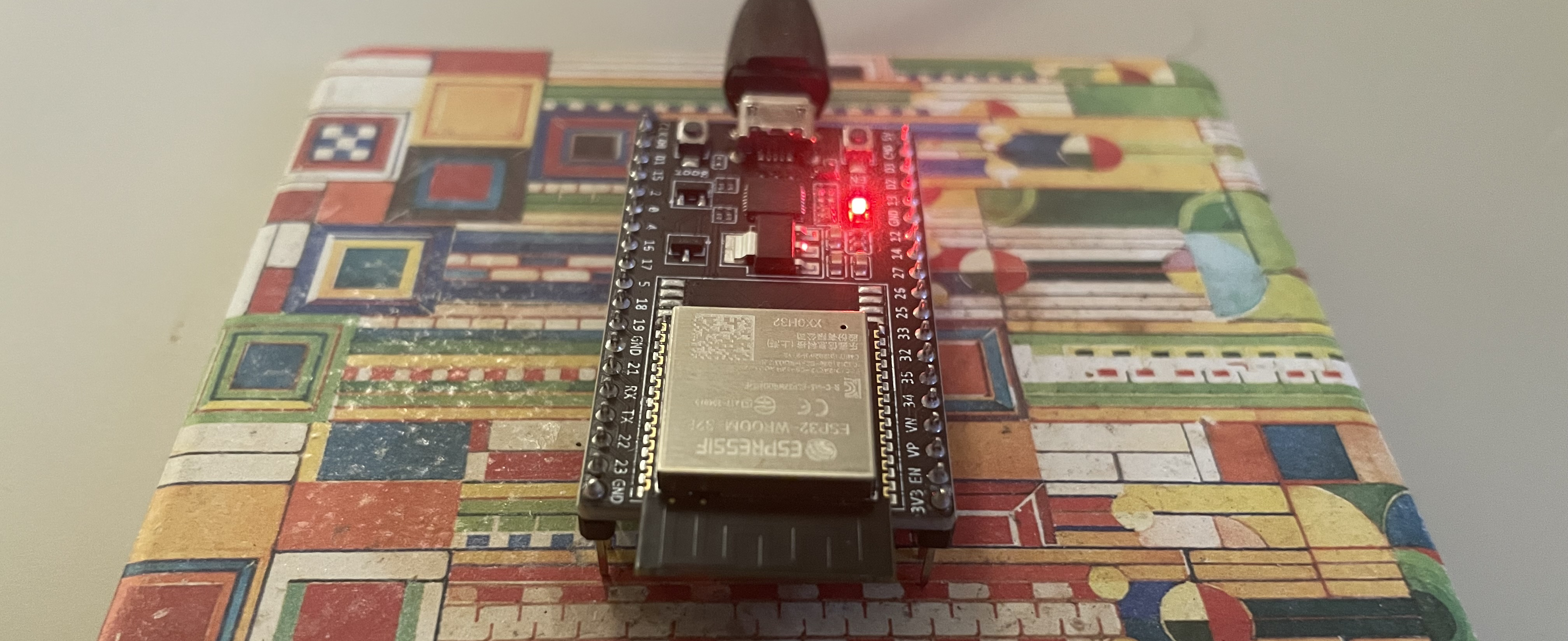 An ESP32 devkit board plugged in, with a red LED shining.